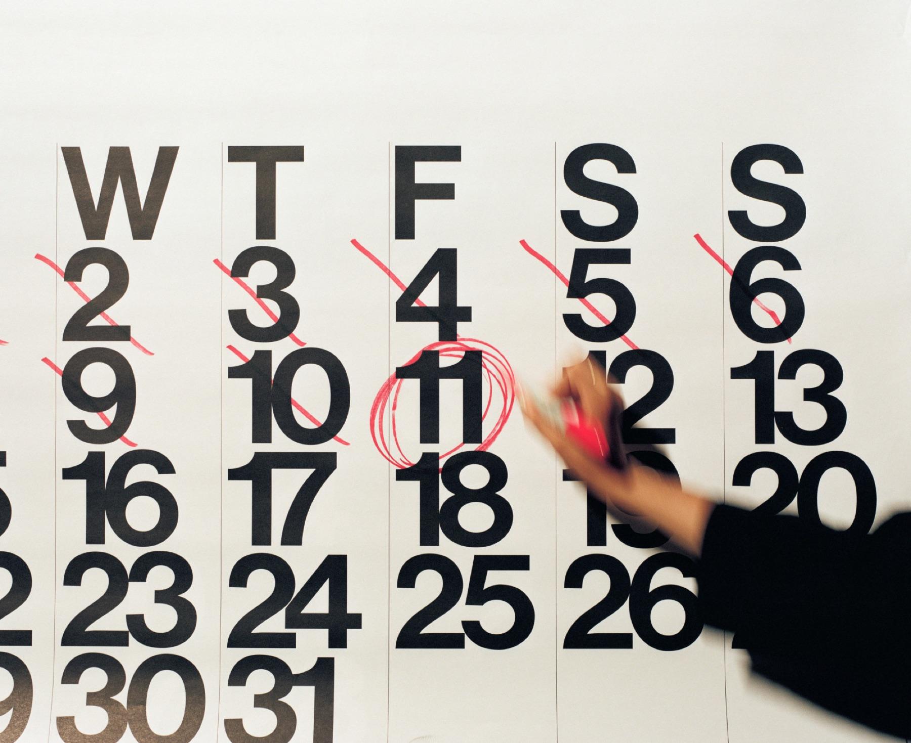 A wall calendar with past days crossed off and one date circled