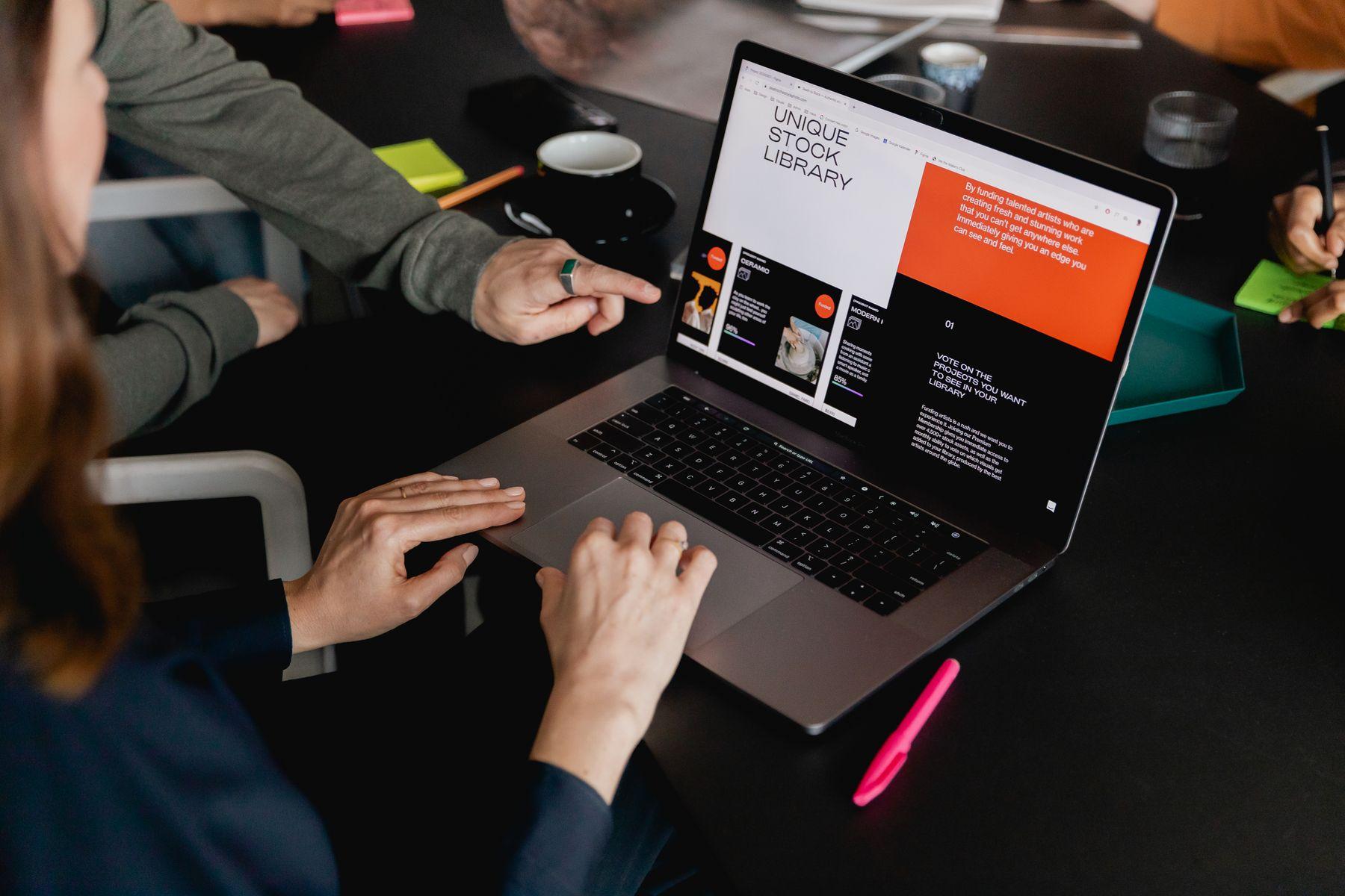 A laptop showing a store page beside sticky notes and a notebook