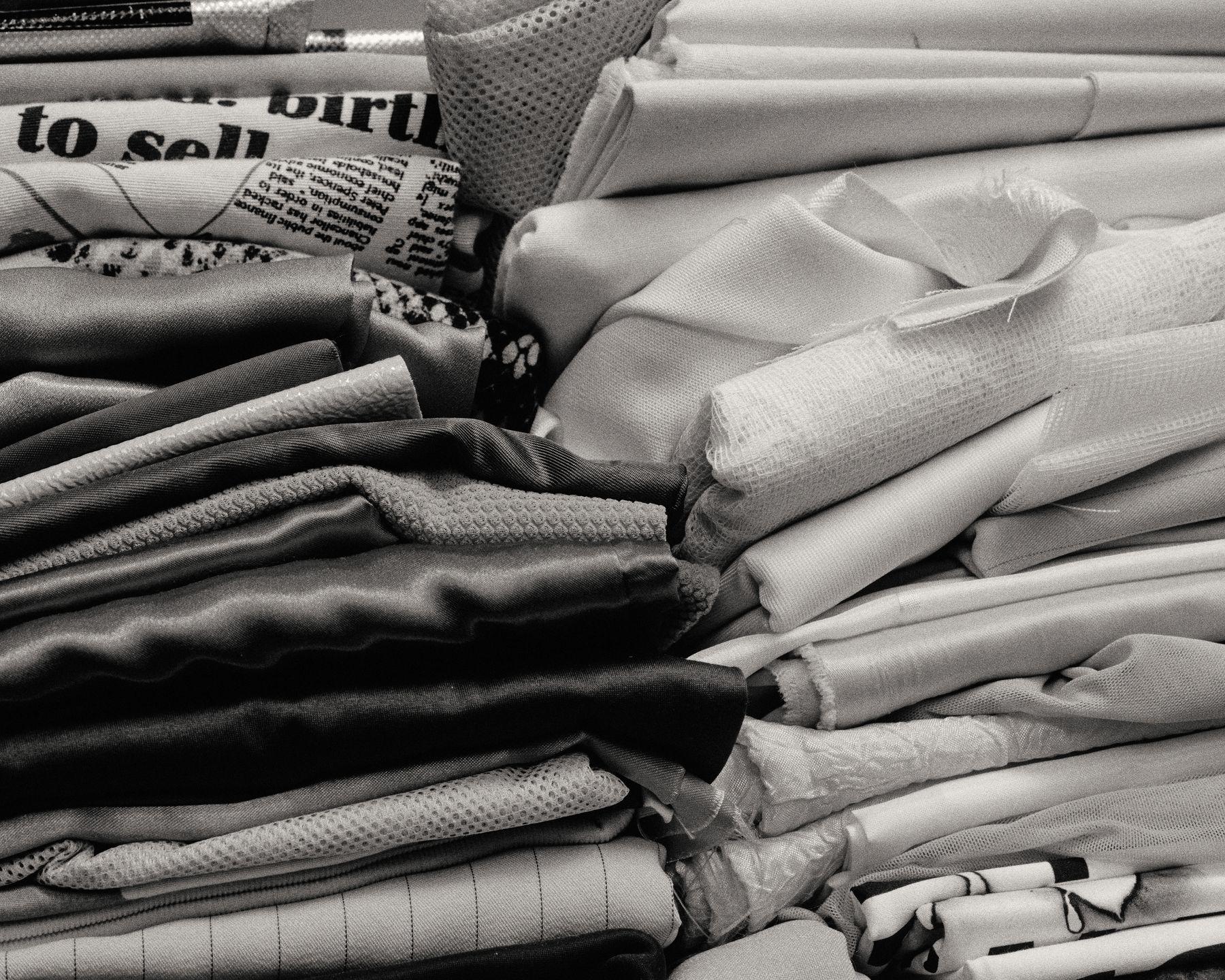 Stacks of folded fabric shelved in black and white