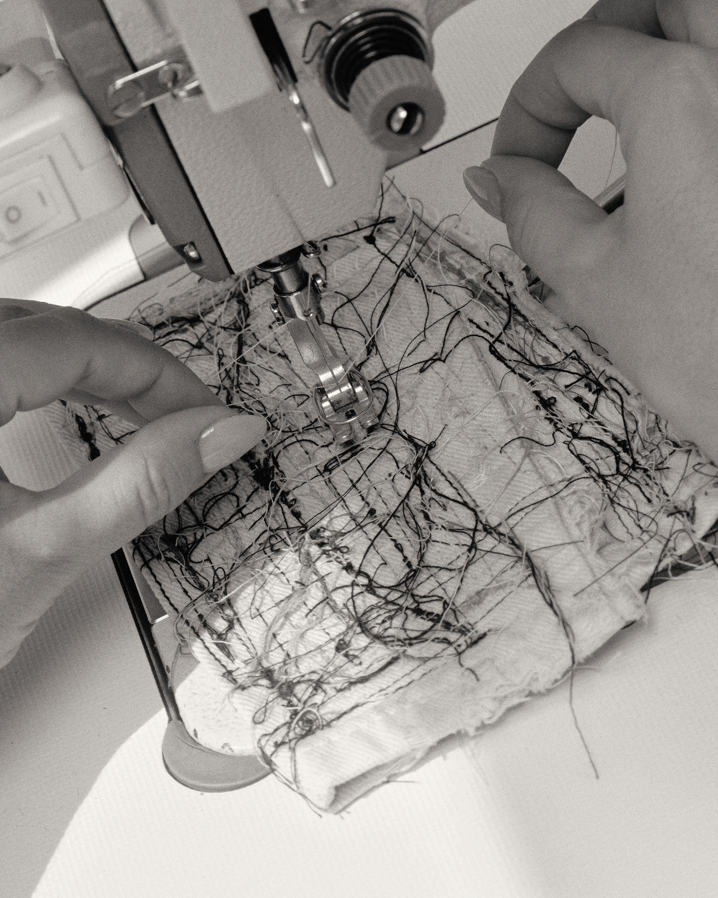 A tangle of dark thread under a sewing machine