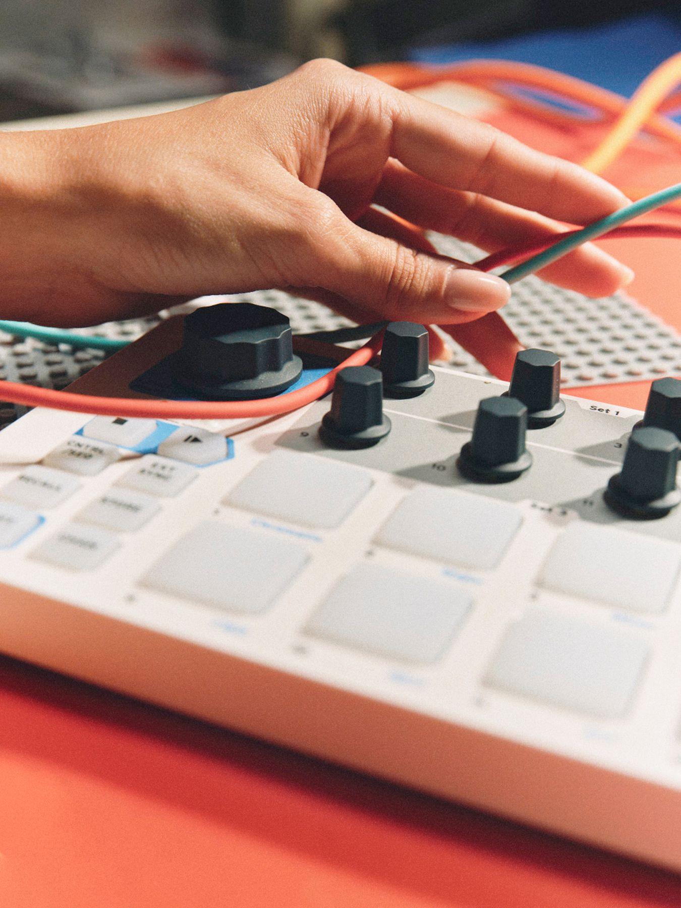 A hand connecting cables to a controller