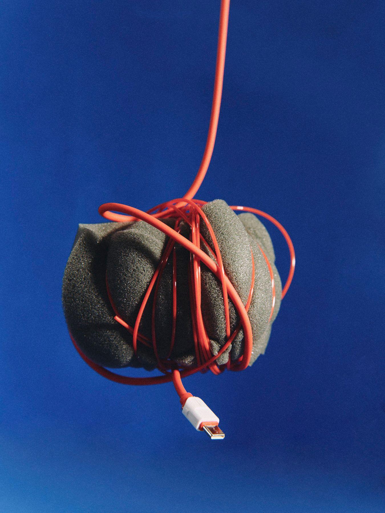 A ball of tangled cable hanging against blue