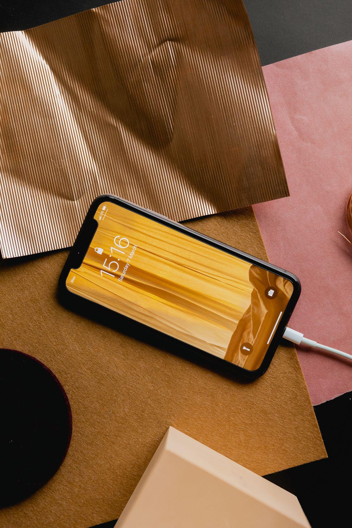 A phone lying on patterned paper and material samples
