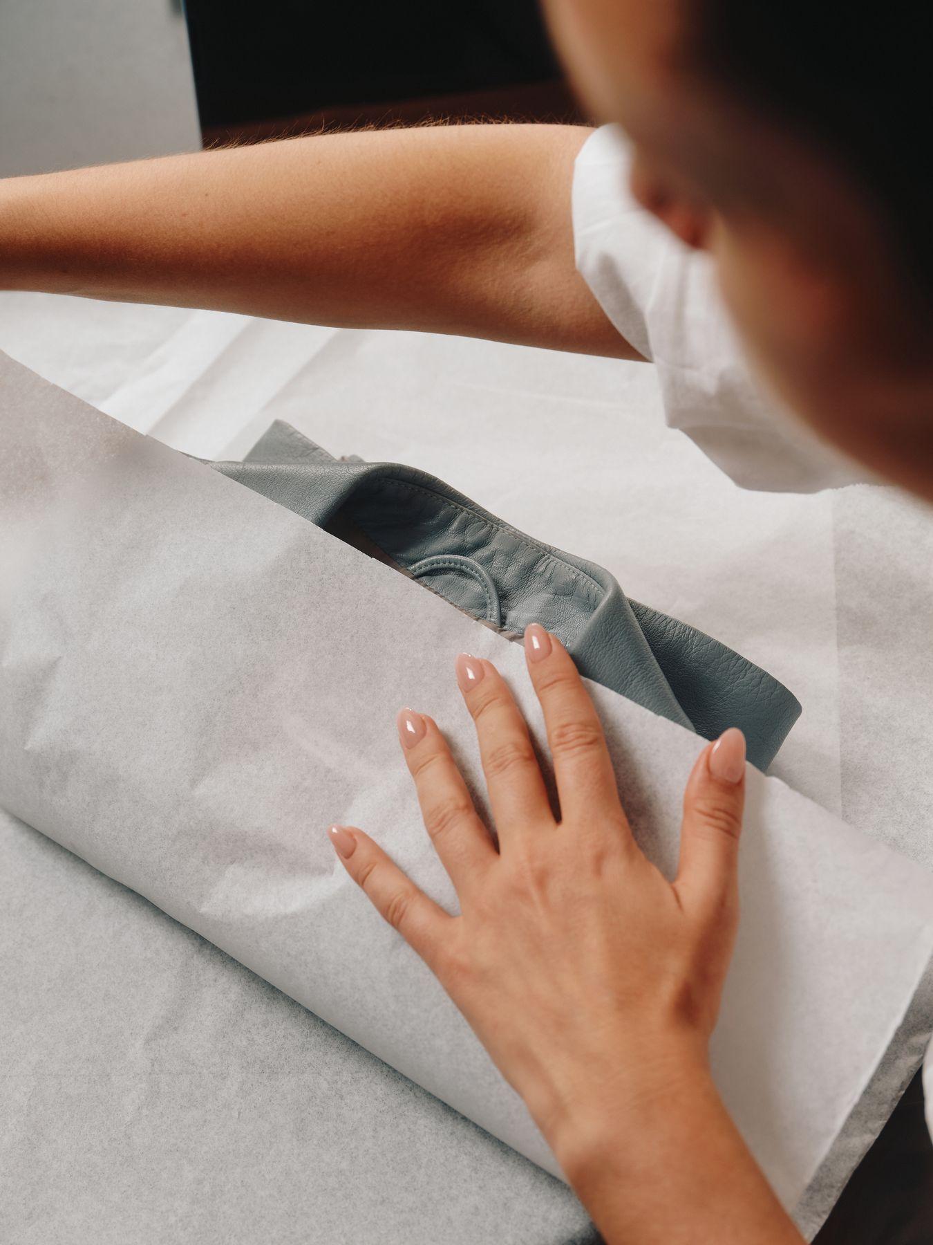 Hands folding tissue paper around an order