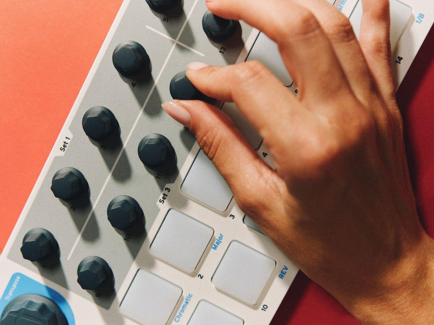 A hand turning dials on a controller