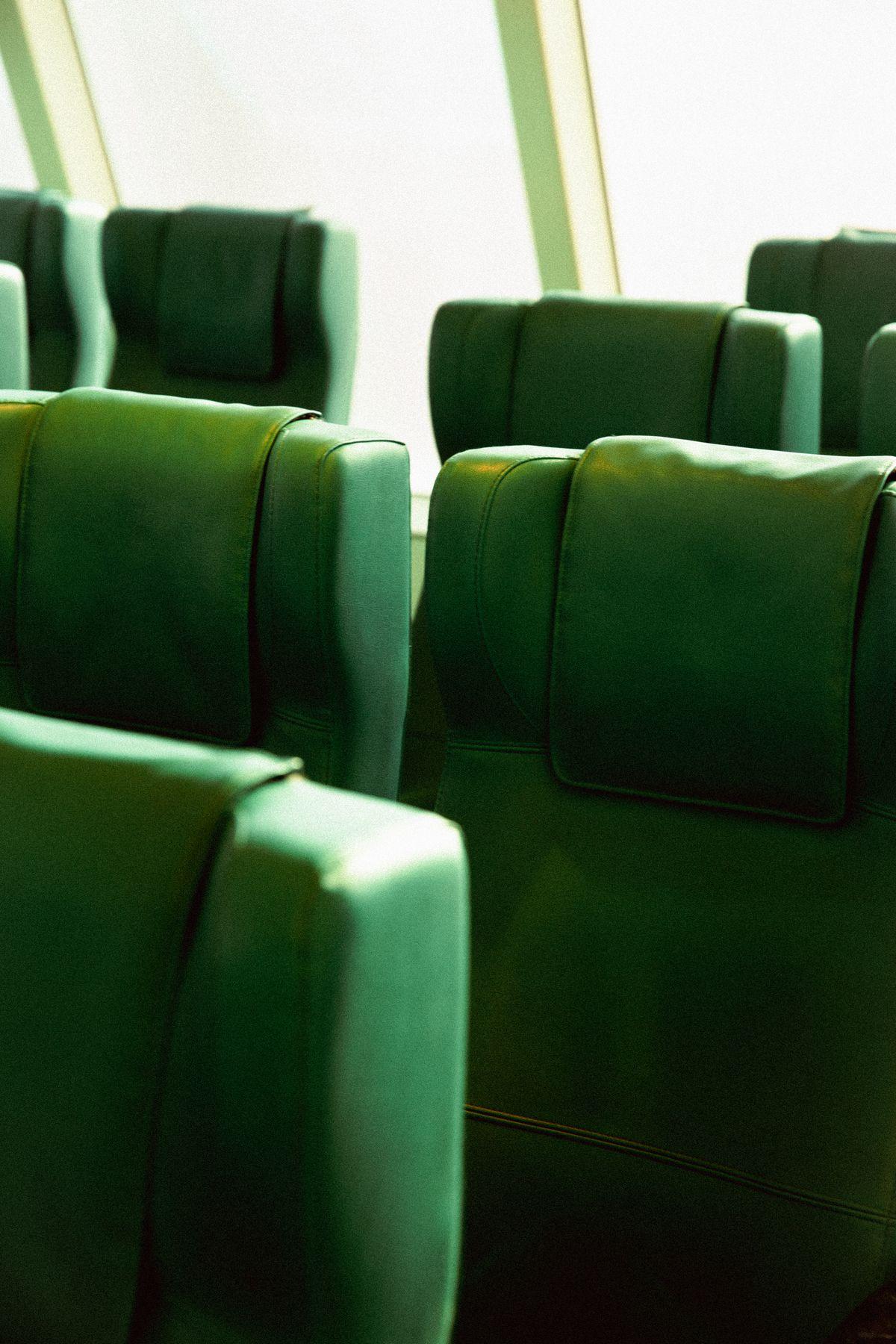 Rows of empty green train seats in the sun